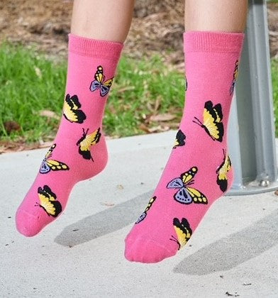 Pink butterfly socks on a sock model playing at the park
