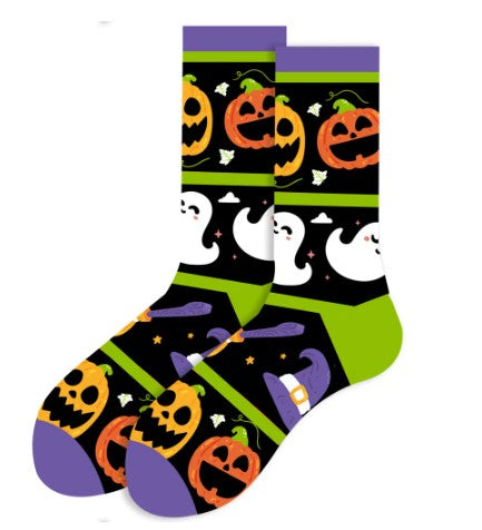 A pair of Halloween-themed socks with a pattern featuring jack o lanterns, ghosts, and witch hats in black, purple, and green colors.