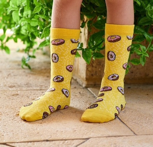 Yellow donut socks with sprinkles worn by model