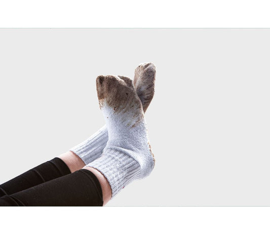 Person wearing a pair of dirty white socks
