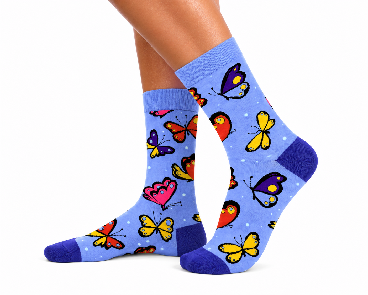 A pair of crew socks worn on a person's feet, featuring a light blue background with a colorful pattern of cartoon butterflies and hearts, set against a plain white background.