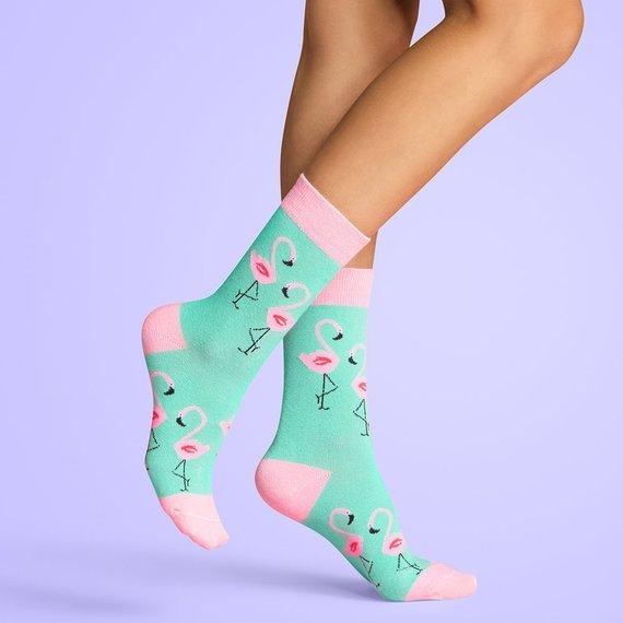 Turquoise socks with pink trim and flamingo print worn by model