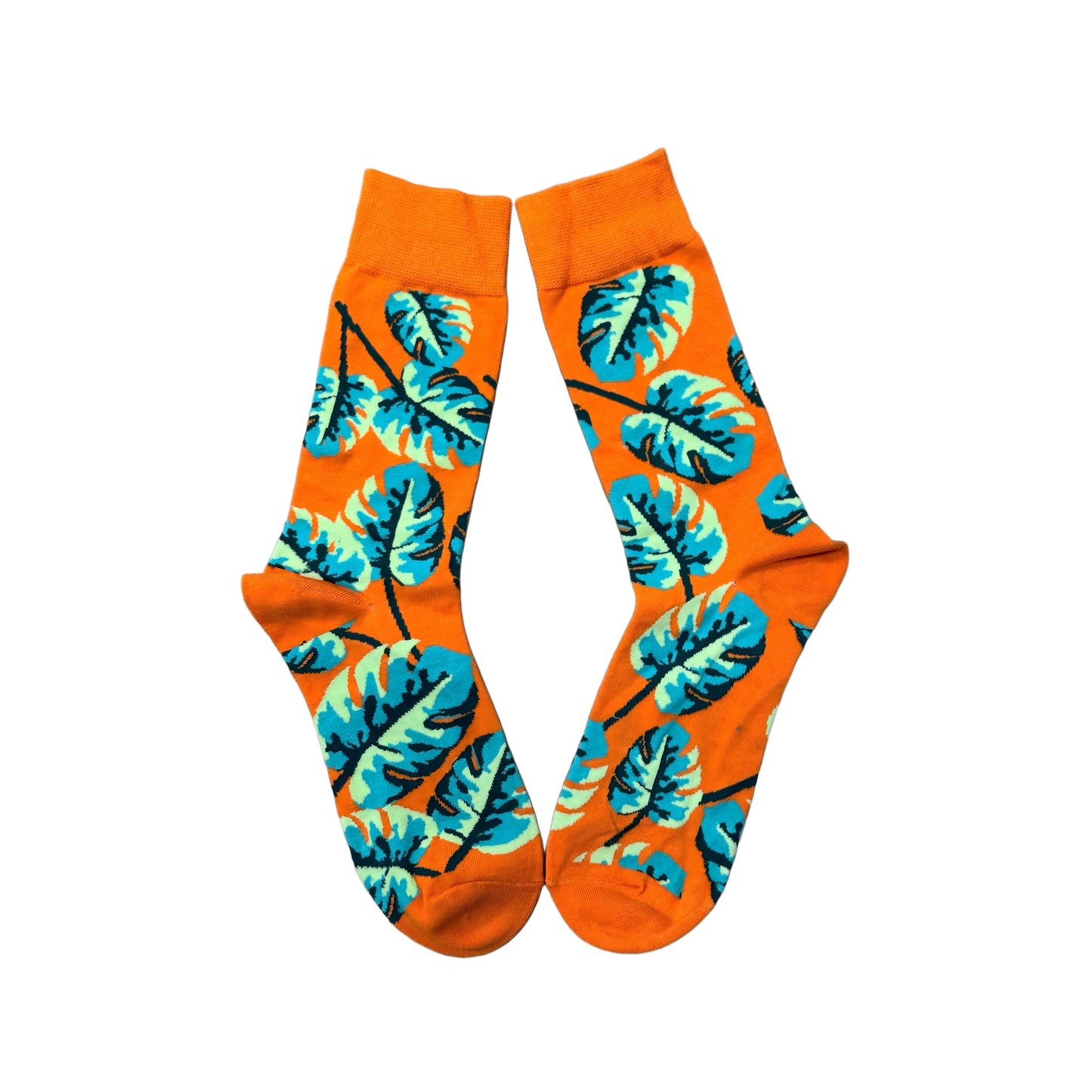 Orange socks featuring monstera plant leaves