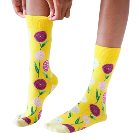 Yellow socks with floral patterns worn by a person on a white background