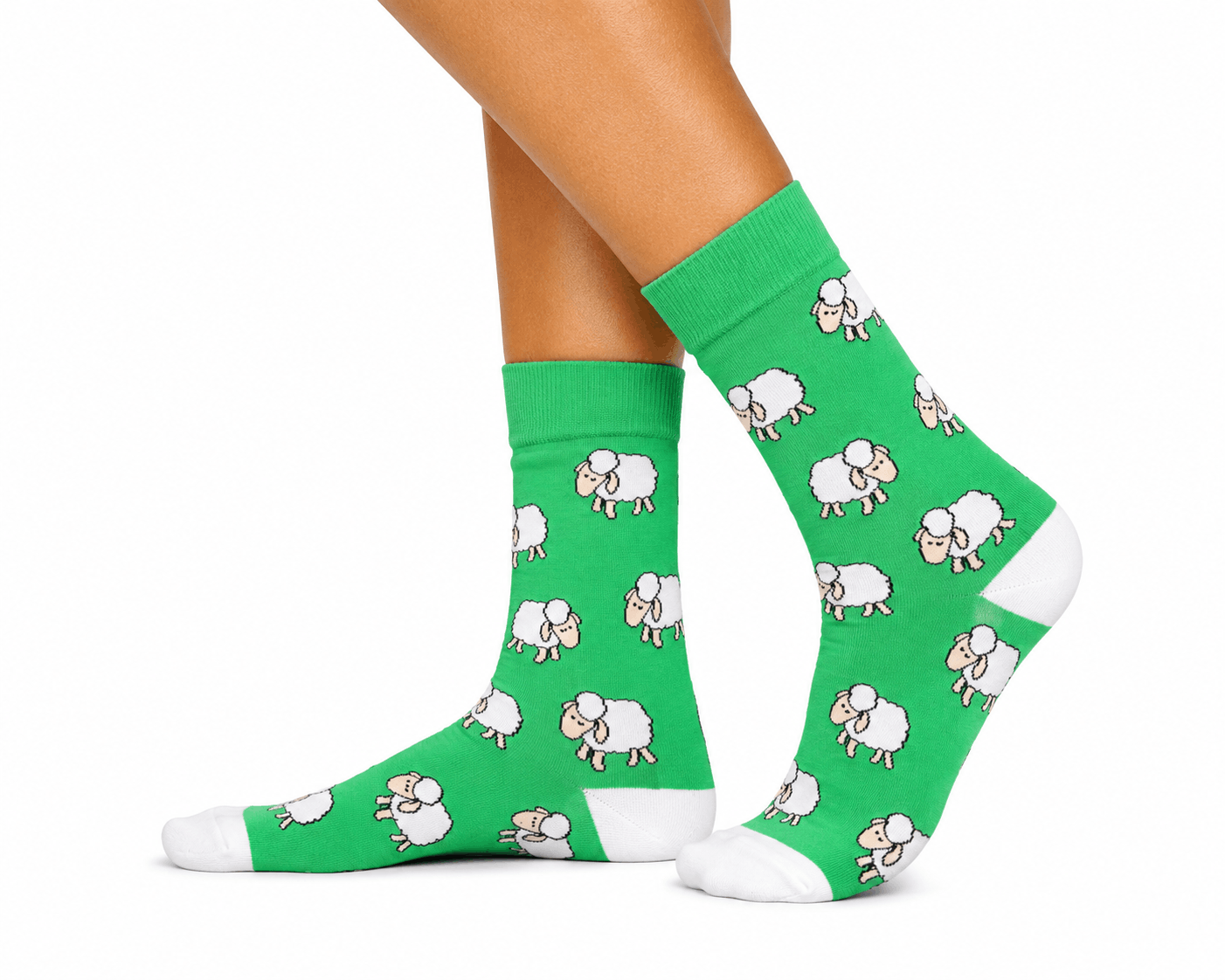 A pair of bright green crew socks with a repeating white sheep pattern, worn on a person's feet against a plain white background.
