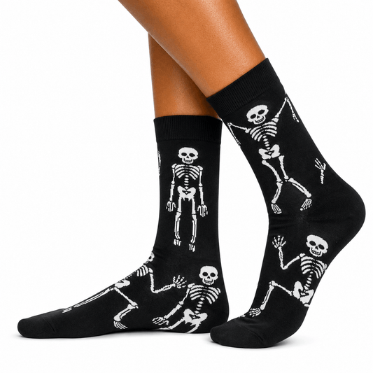 Black crew socks with a white skeleton pattern, shown on a person's feet against a plain white background.