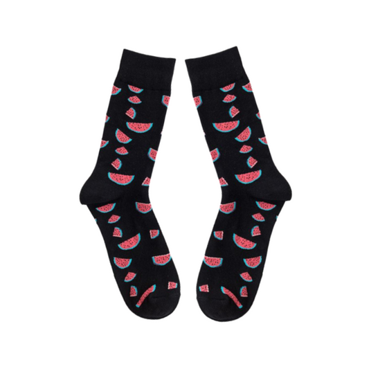 Black socks with slices of watermelon laid flat on white background