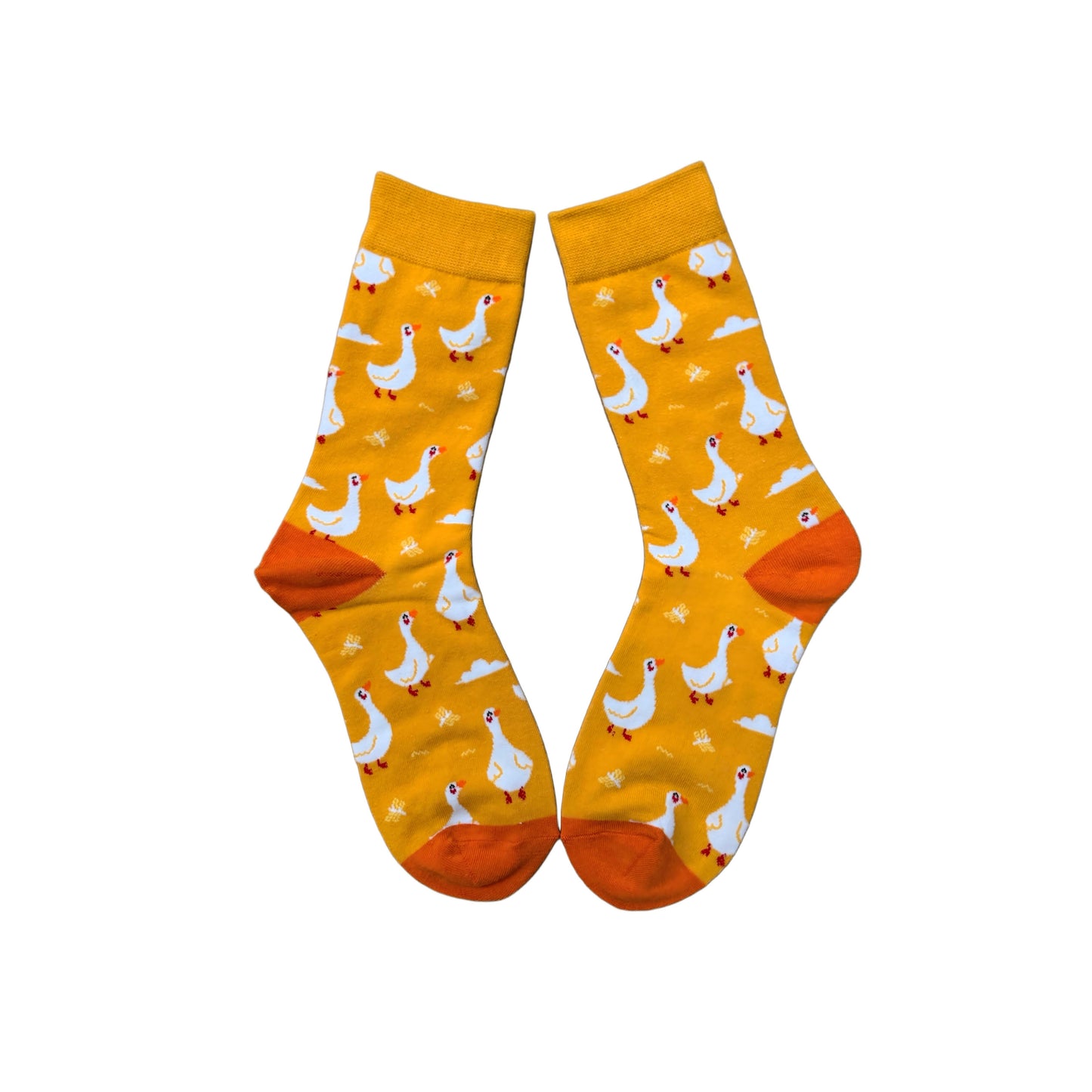 Yellow socks with white geese on them laid flat, with orange heel and toe.