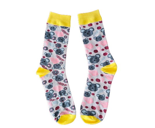 Pair of socks with koala and floral pattern on a pale pink background